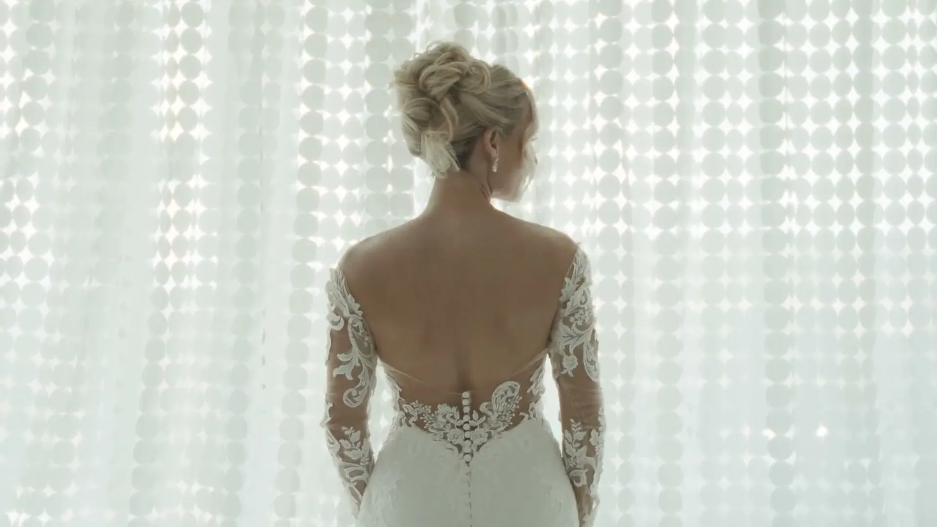 A bride in a lace dress in soft window light